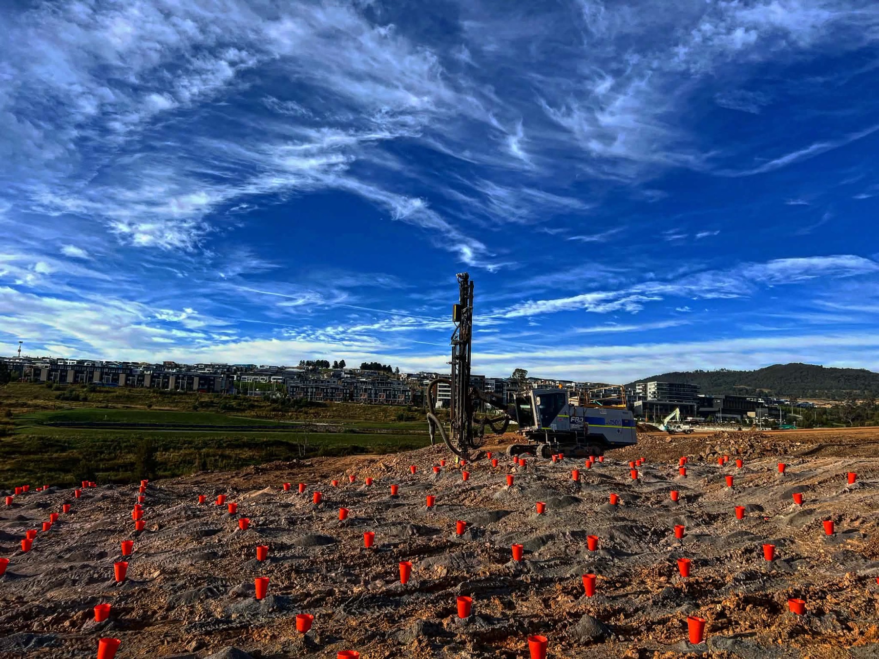 Blast pattern marked out with cones beside a residential estate