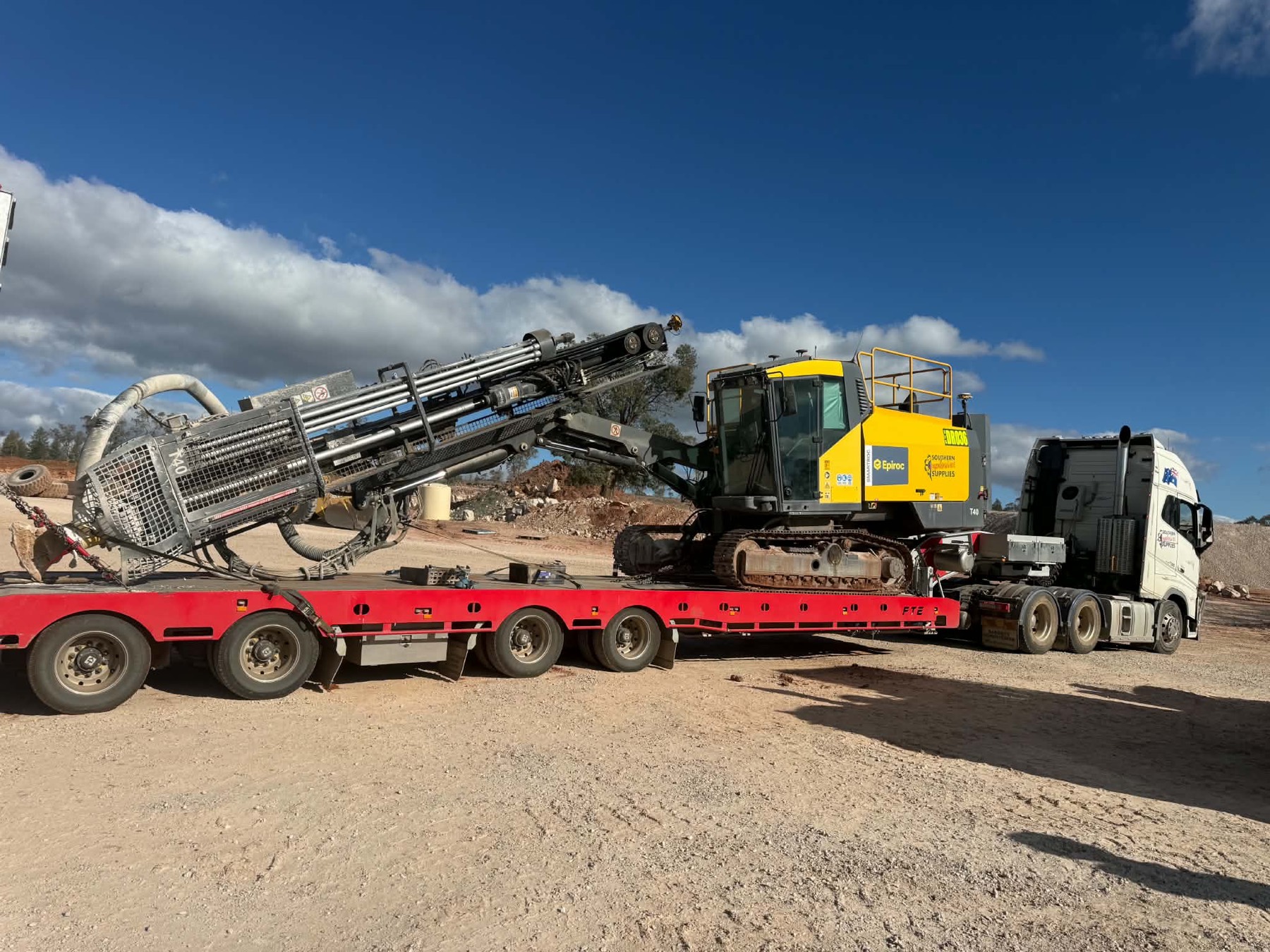 Epiroc drill rig loaded on a float trailer for transport