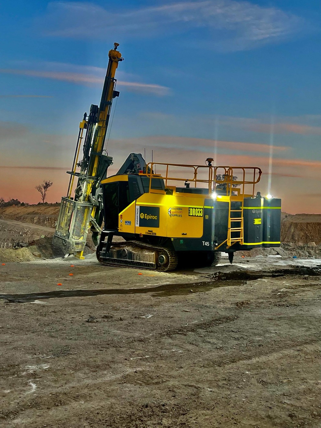 Yellow Epiroc T45 drilling at dusk