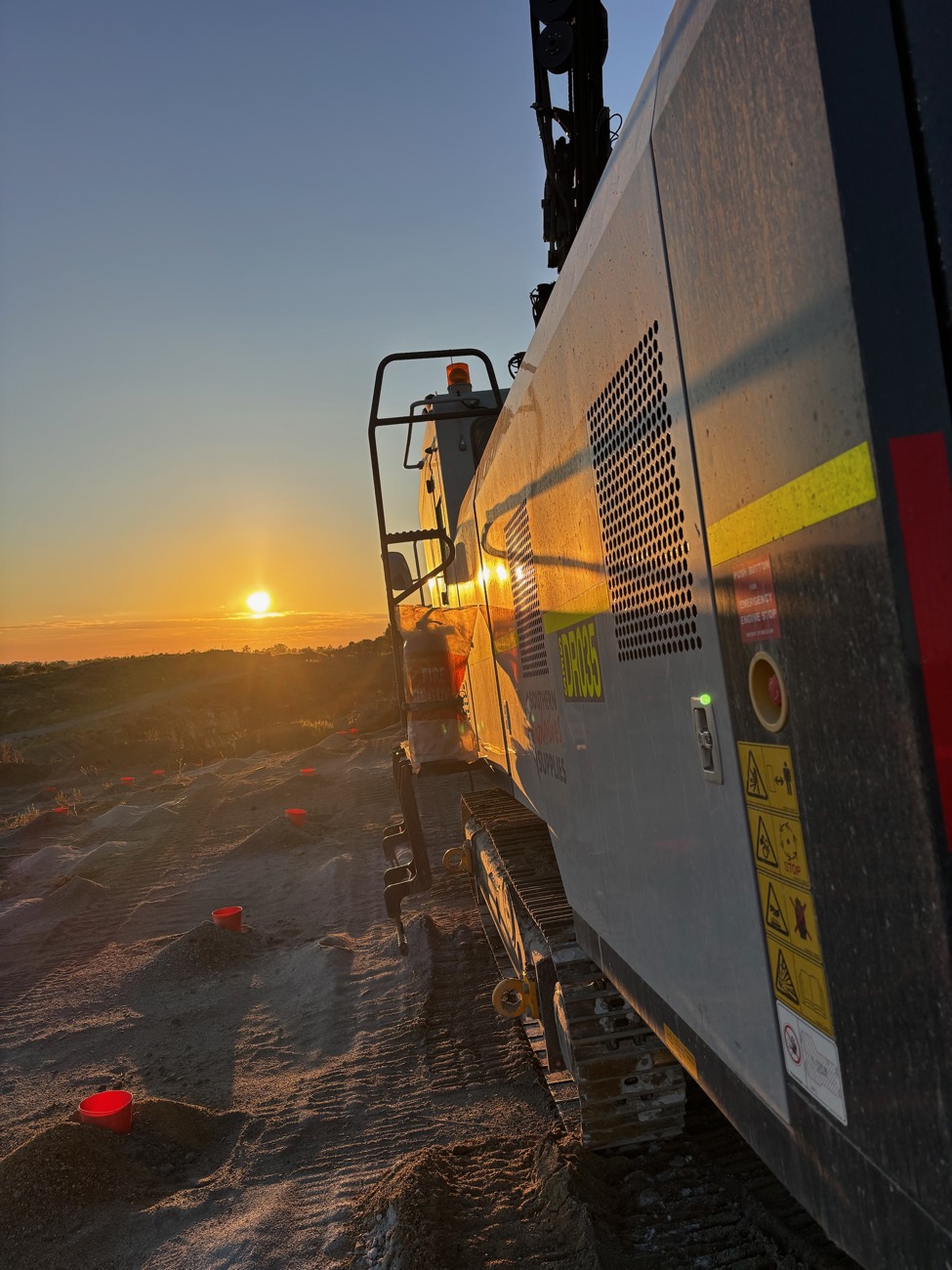 Sun setting along the side of a drill rig